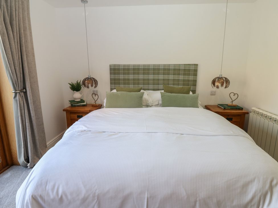 A bedroom with a bed and lamps at The Cart House in Snape near Bedale