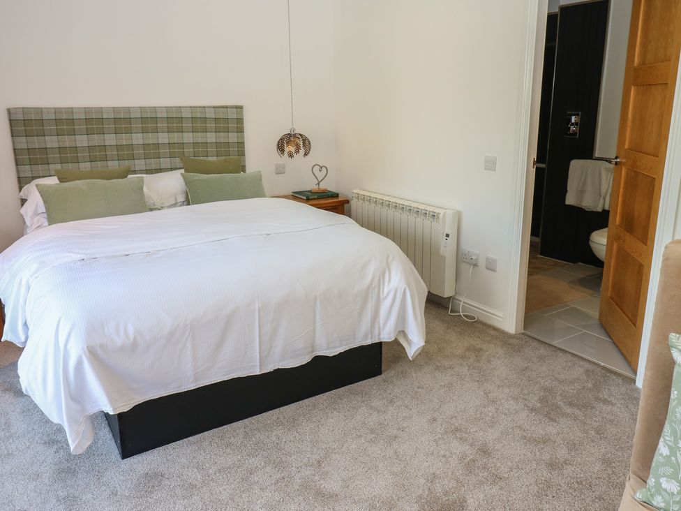 A bedroom with a bed and bedside table at The Cart House Snape near Bedale