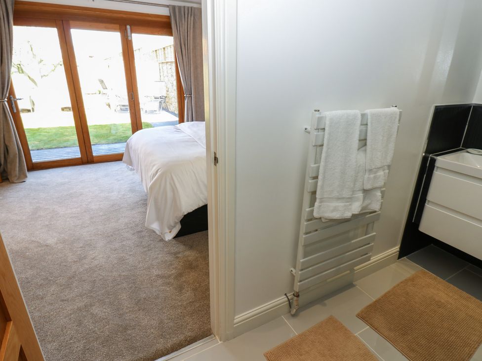 A bedroom with a towel radiator and double doors at The Cart House in Snape near Bedale