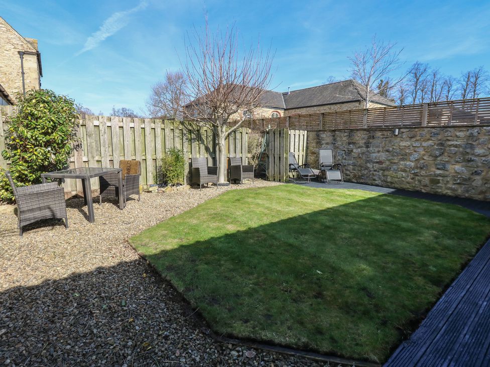 A garden with a table and chairs at The Cart House in Snape near Bedale
