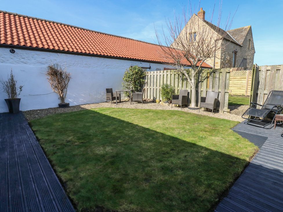 A garden with grass and seating area at The Cart House in Snape near Bedale