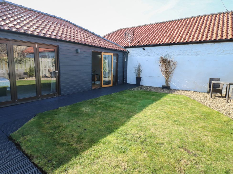A garden with a lawn and seating area at The Cart House Snape near Bedale