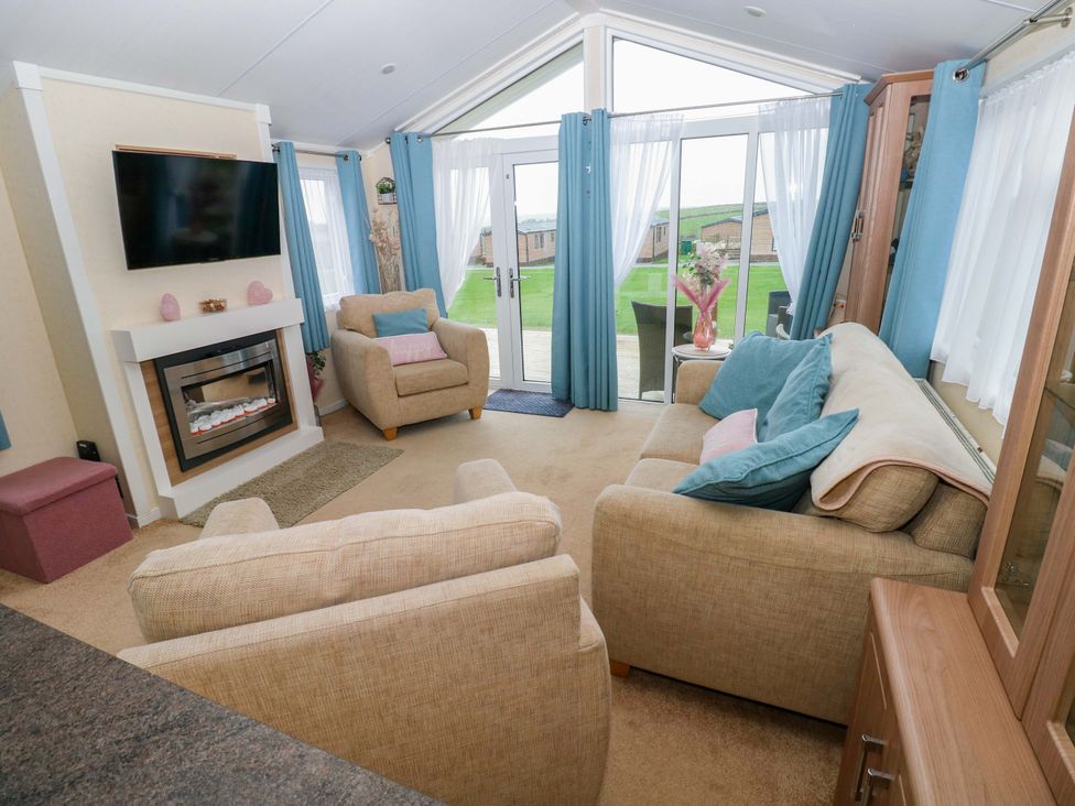 A living room with sofa and armchairs at Gentle Tide Hasguard Cross near Little Haven
