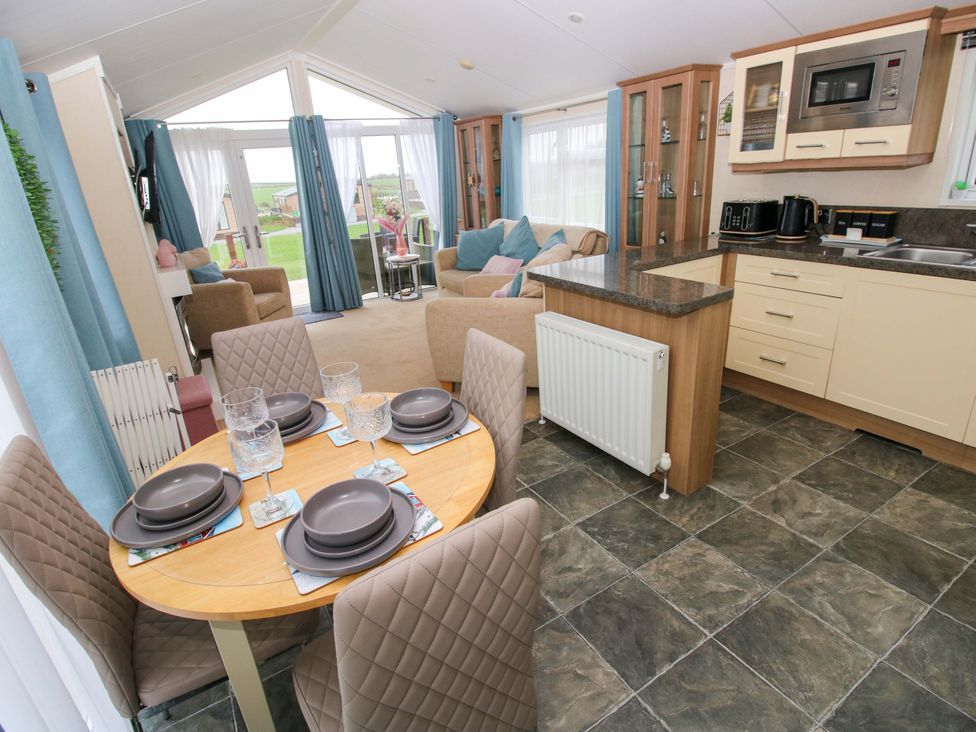 A living room with a dining area and kitchen at Gentle Tide Hasguard Cross near Little Haven