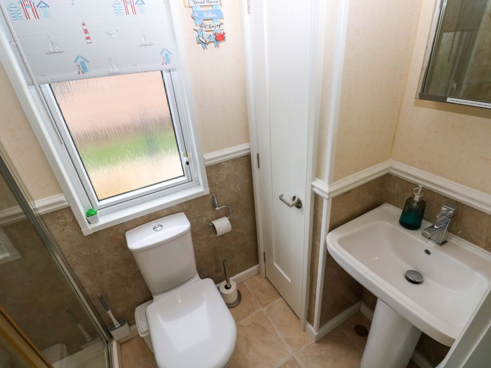 A bathroom with a toilet and sink at Gentle Tide Hasguard Cross near Little Haven