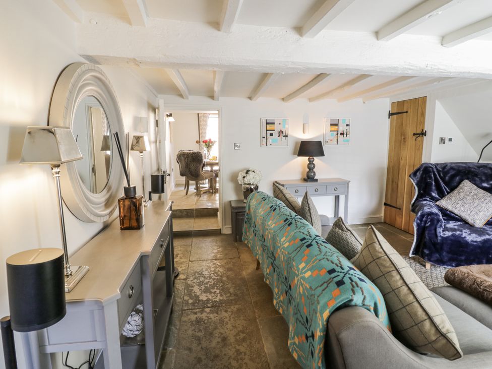 A living room with a sofa and dining area at Cotstone Cottage in Chipping Campden