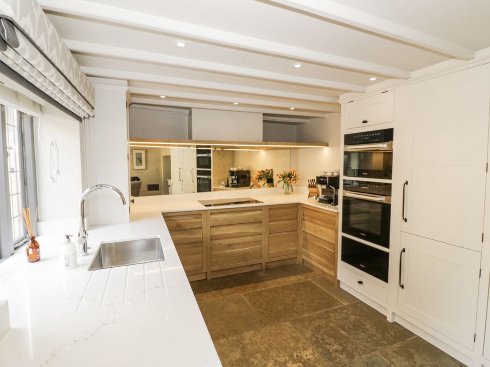 A kitchen with cabinets and appliances at Cotstone Cottage in Chipping Campden
