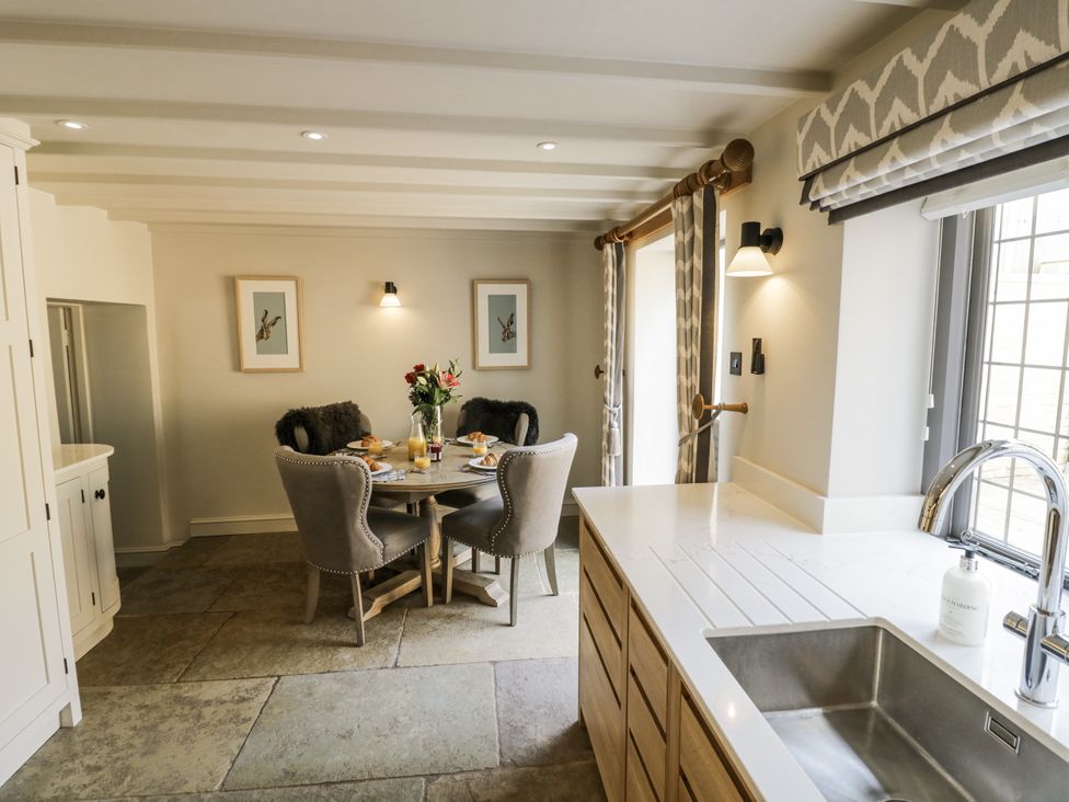 A kitchen with a dining table and chairs at Cotstone Cottage in Chipping Campden