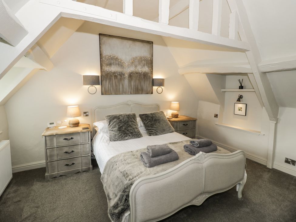 A bedroom with a bed and nightstand at Cotstone Cottage in Chipping Campden