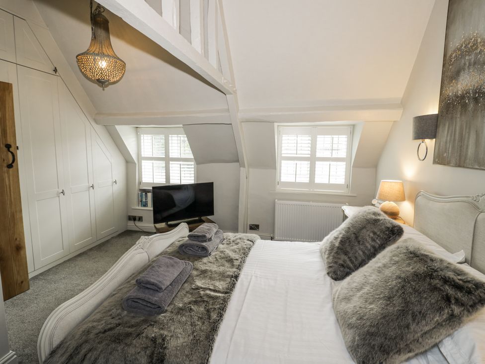 A bedroom with a bed and wardrobe at Cotstone Cottage, Chipping Campden