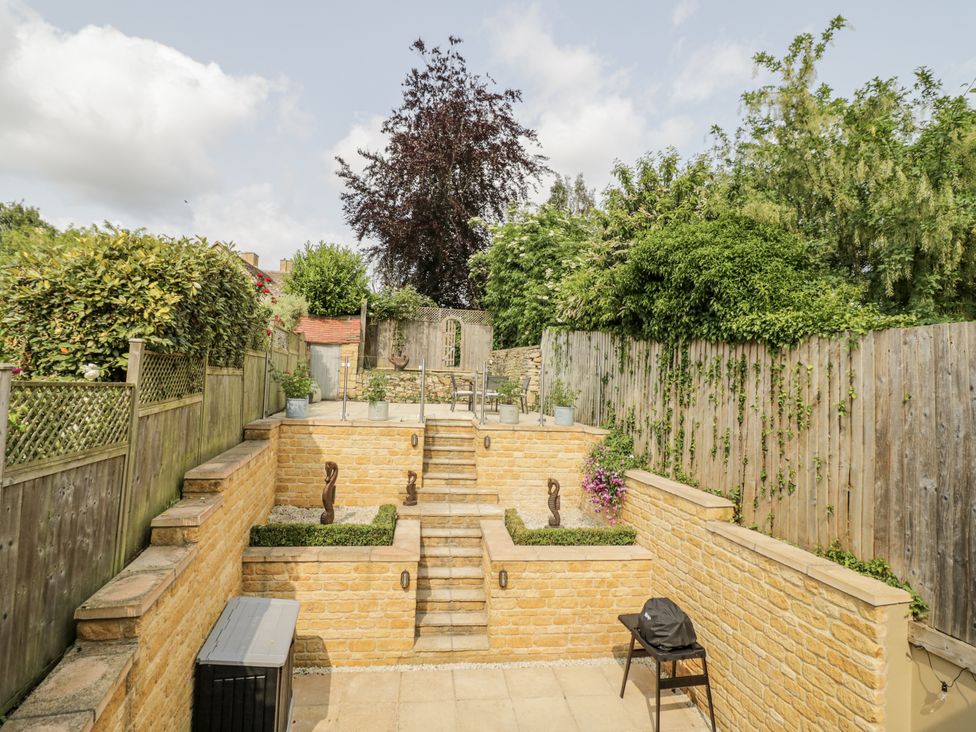 A garden with stairs and decorative features at Cotstone Cottage in Chipping Campden