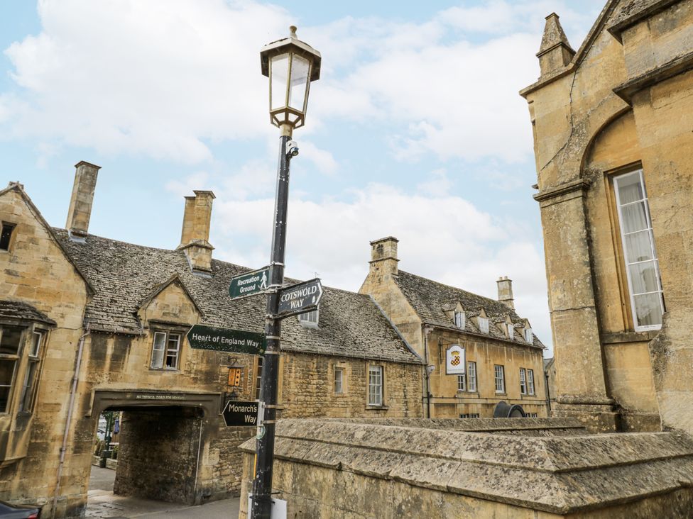 An outdoor street view with buildings and a signpost at Cotstone Cottage in Chipping Campden