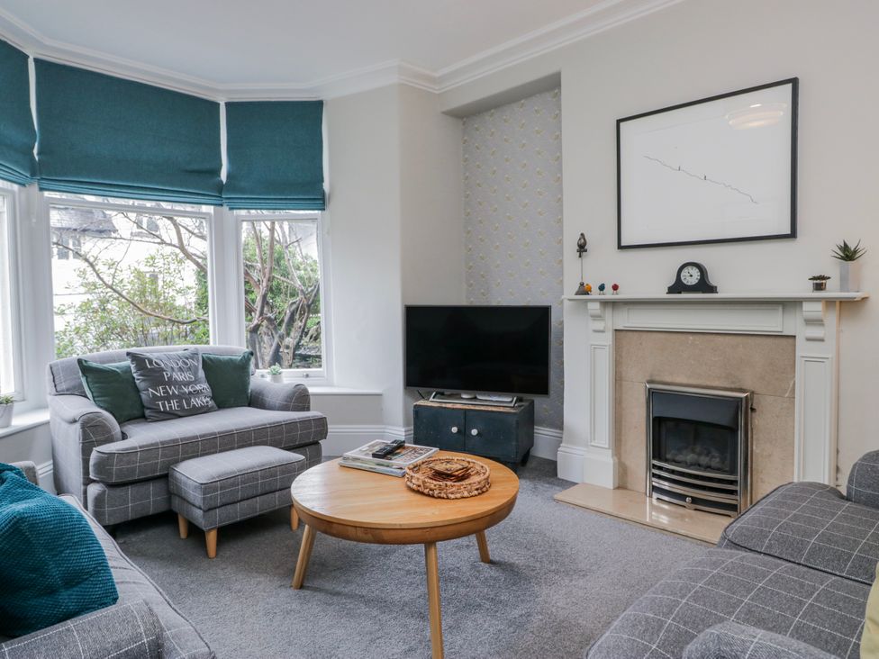 A living room with a sofa and television at The Thistles in Bowness-On-Windermere