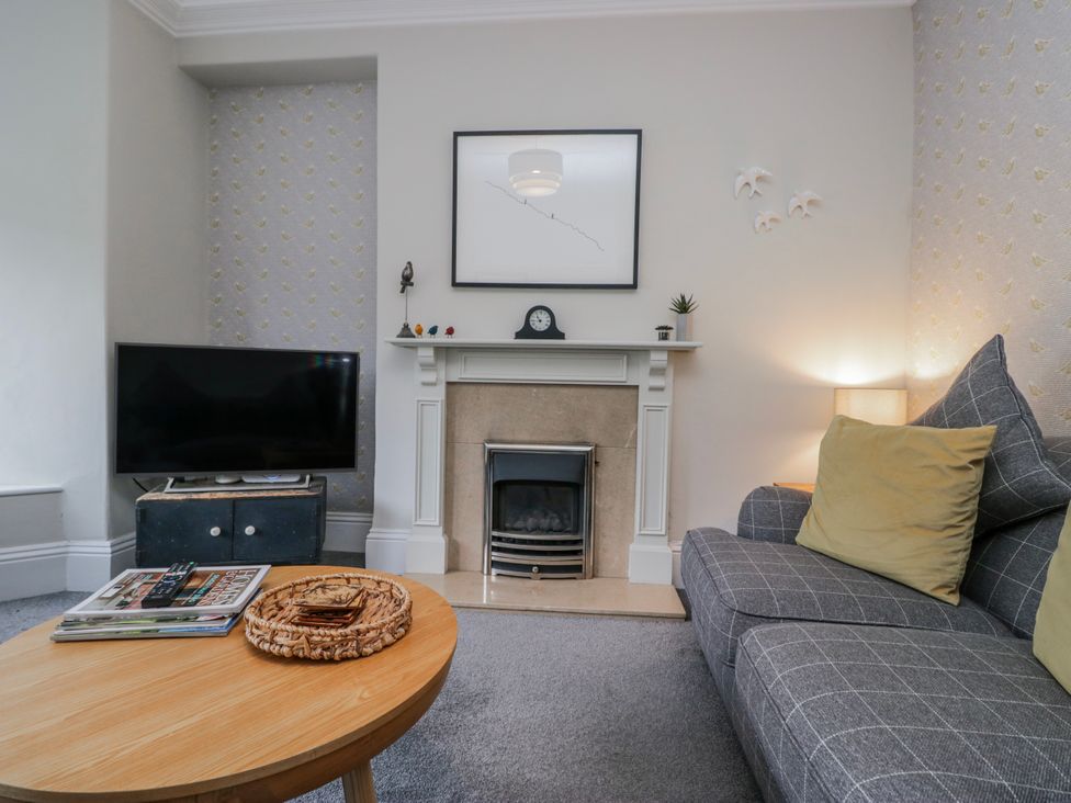 A living room with a television and a coffee table at The Thistles Bowness-On-Windermere
