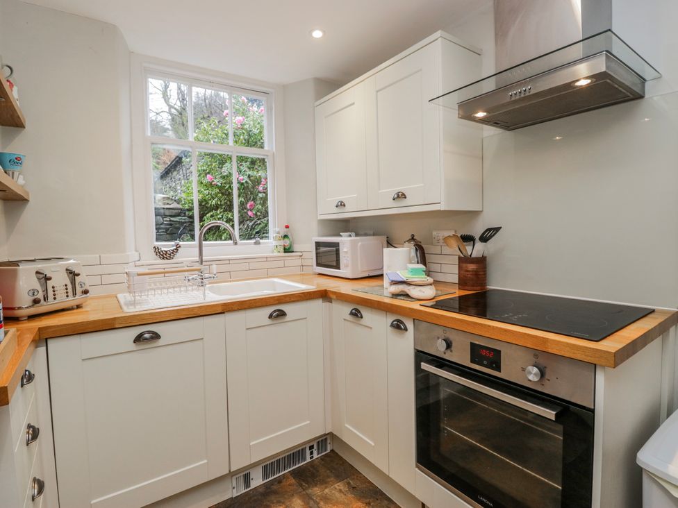 A kitchen with a sink and stove at The Thistles in Bowness-On-Windermere