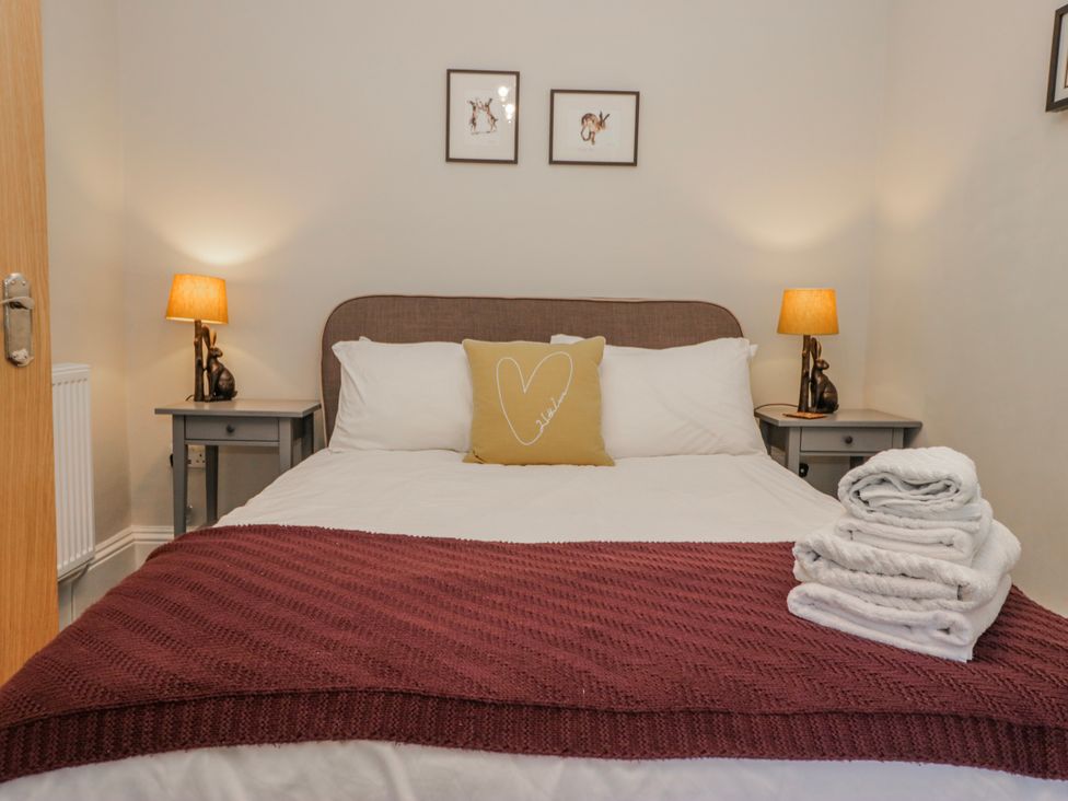 A bedroom with a bed and nightstands at The Thistles in Bowness-On-Windermere