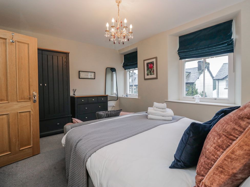 A bedroom with a bed and wardrobe at The Thistles in Bowness-On-Windermere