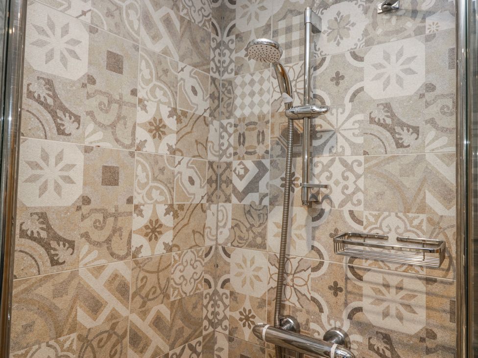 A shower area with patterned tiles at The Thistles Bowness-On-Windermere