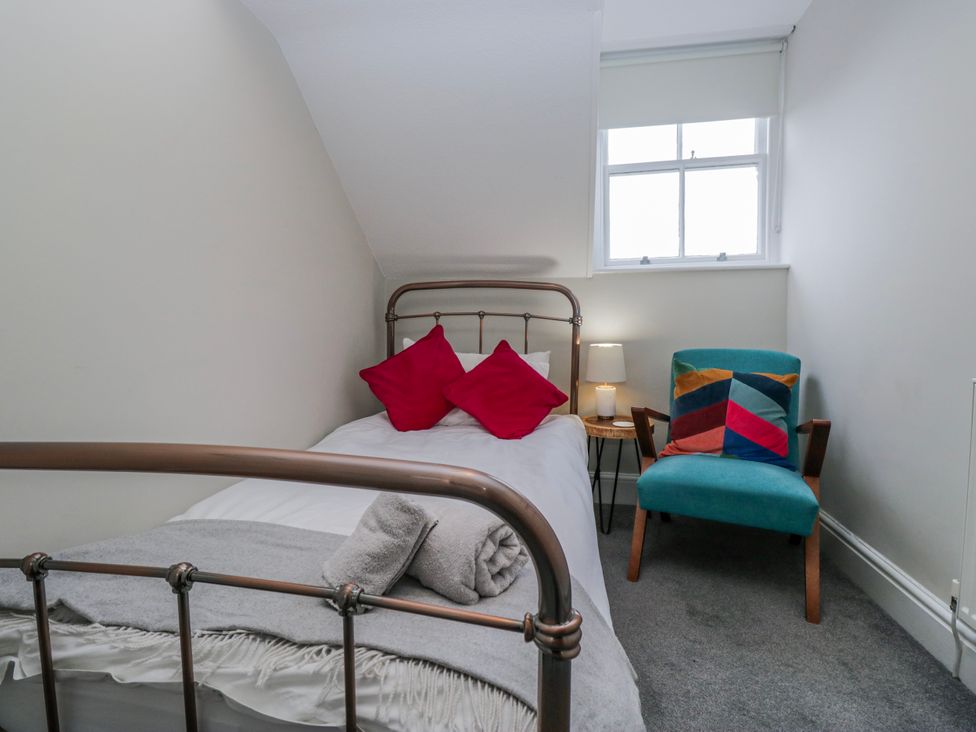 A bedroom with a single bed and chair at The Thistles Bowness-On-Windermere