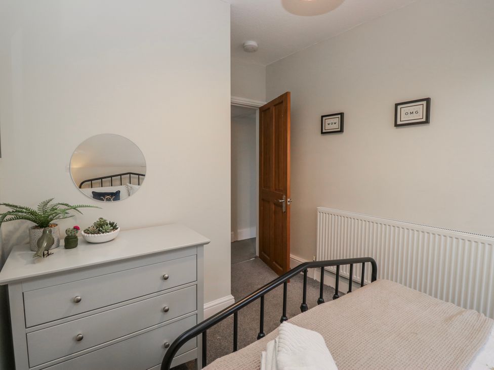 A bedroom with a bed and a dresser at The Thistles in Bowness-On-Windermere