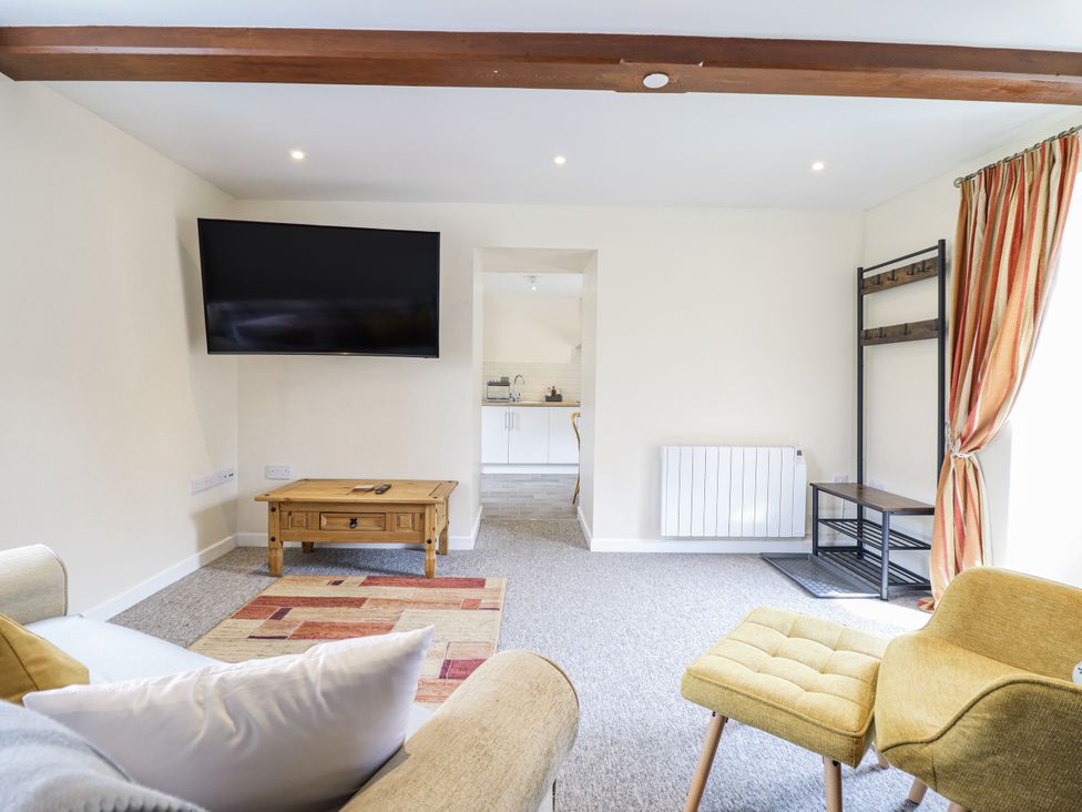 A living room with a television and coffee table at 1 Y Llew in Llandinam