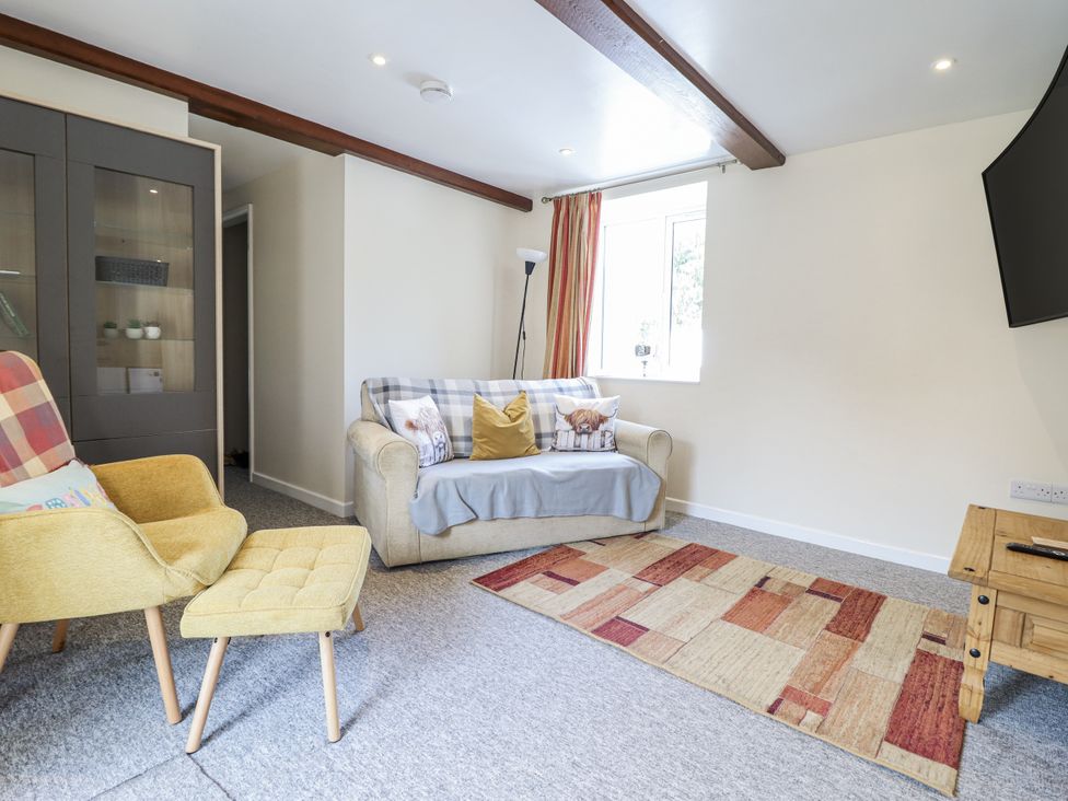A living room with a sofa and armchair at 1 Y Llew in Llandinam