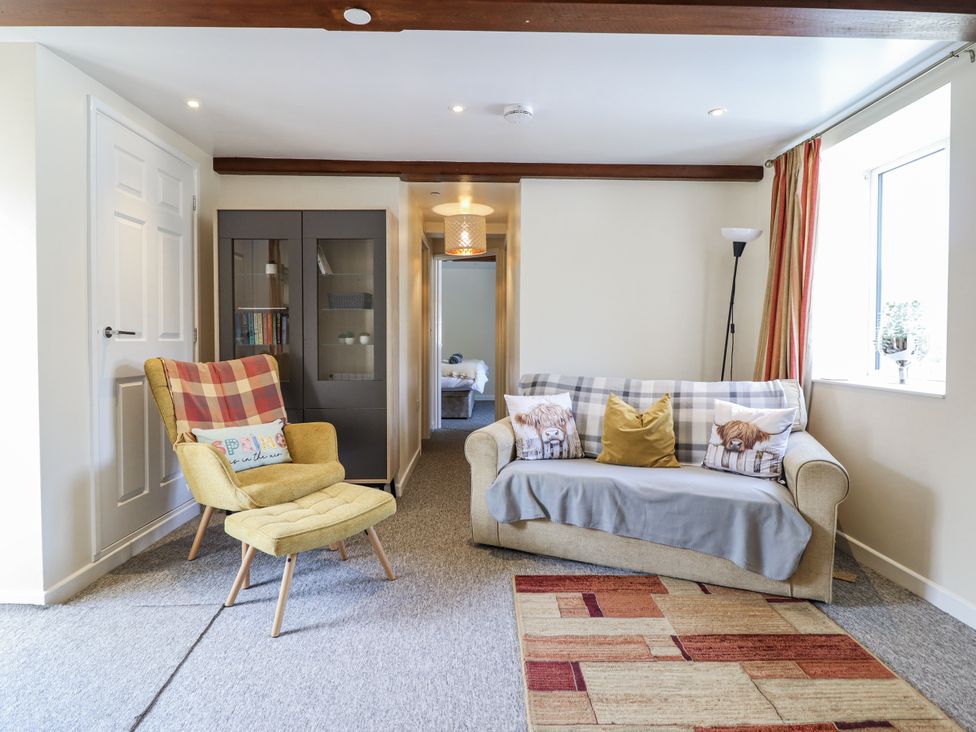 A living room with sofa and armchair at 1 Y Llew in Llandinam