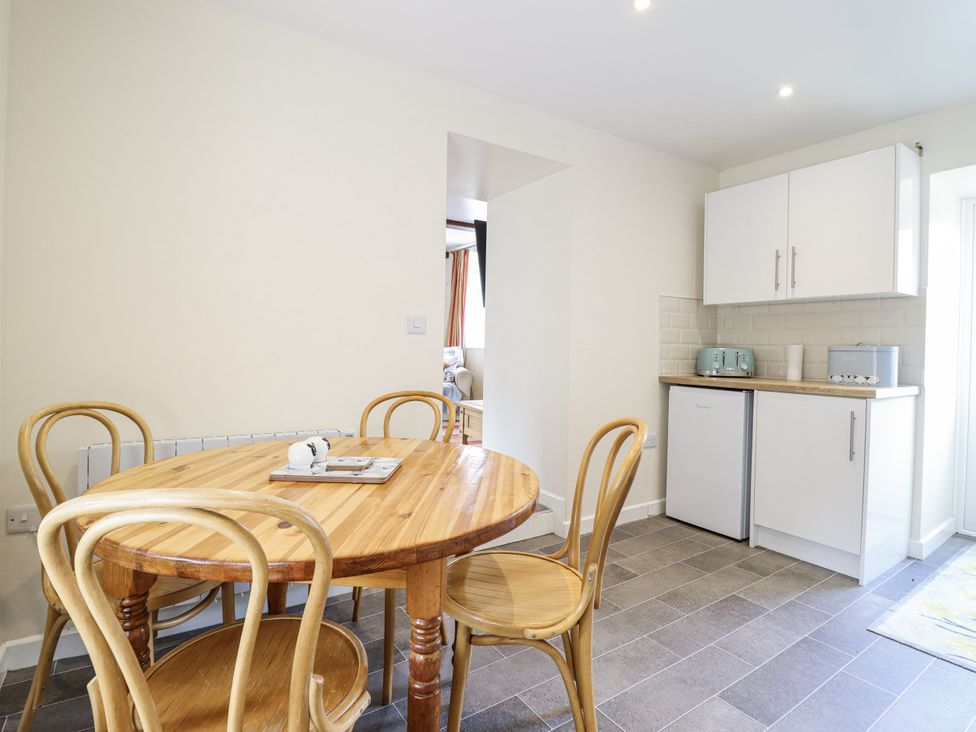 A kitchen with a dining table and chairs at 1 Y Llew, Llandinam