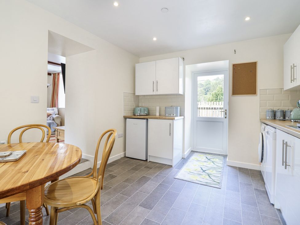A kitchen with a table and chairs at 1 Y Llew in Llandinam