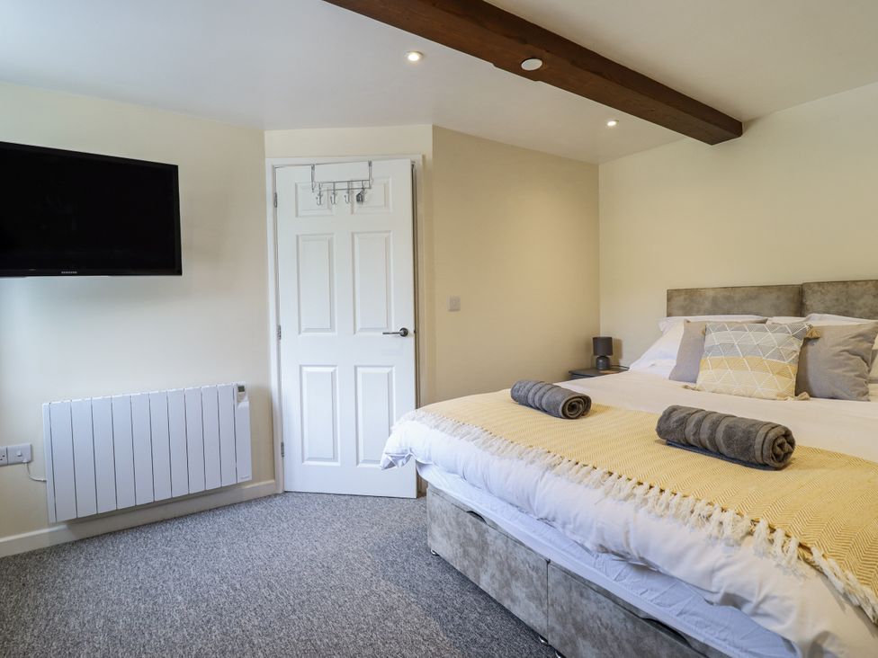 A bedroom with a bed and television at 1 Y Llew in Llandinam