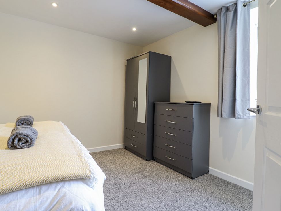 A bedroom with a bed and storage furniture at 1 Y Llew in Llandinam