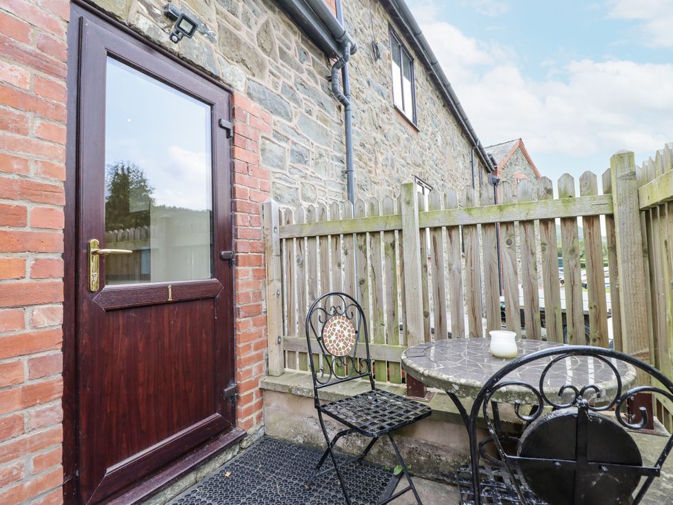 An outdoor area with a table and chair at 1 Y Llew in Llandinam