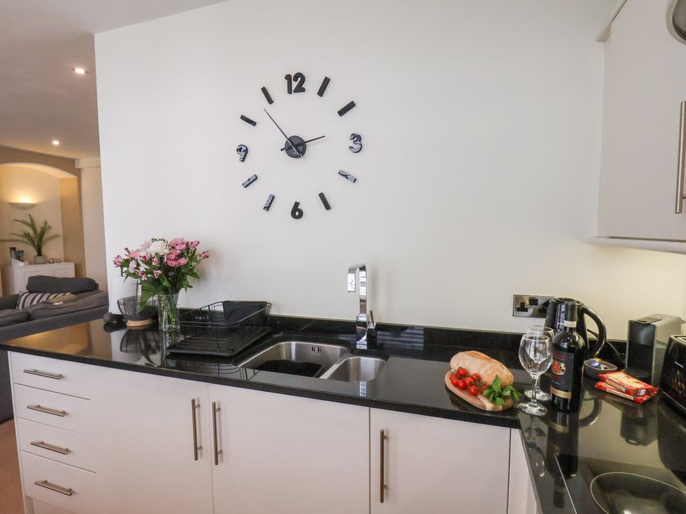 A kitchen with a sink and clock at Jolly Roger in Whitby