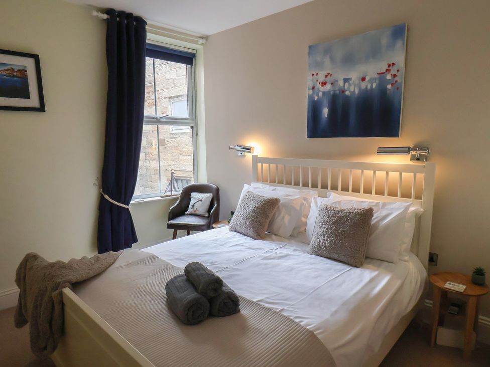 A bedroom with a bed and bedside table at Jolly Roger in Whitby
