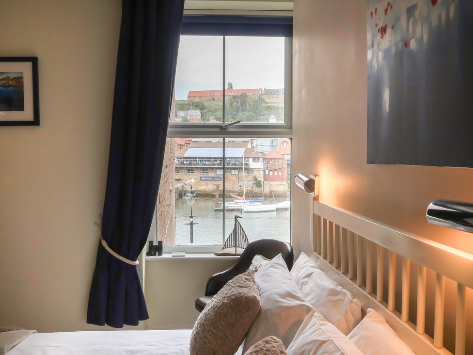 A bedroom with a view of the harbor at Jolly Roger in Whitby