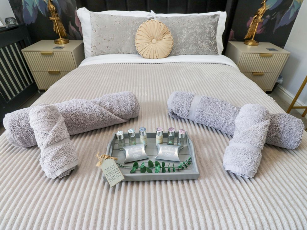 A bedroom with towels and toiletries on a bed at The Snug on the Cobbles in Haworth