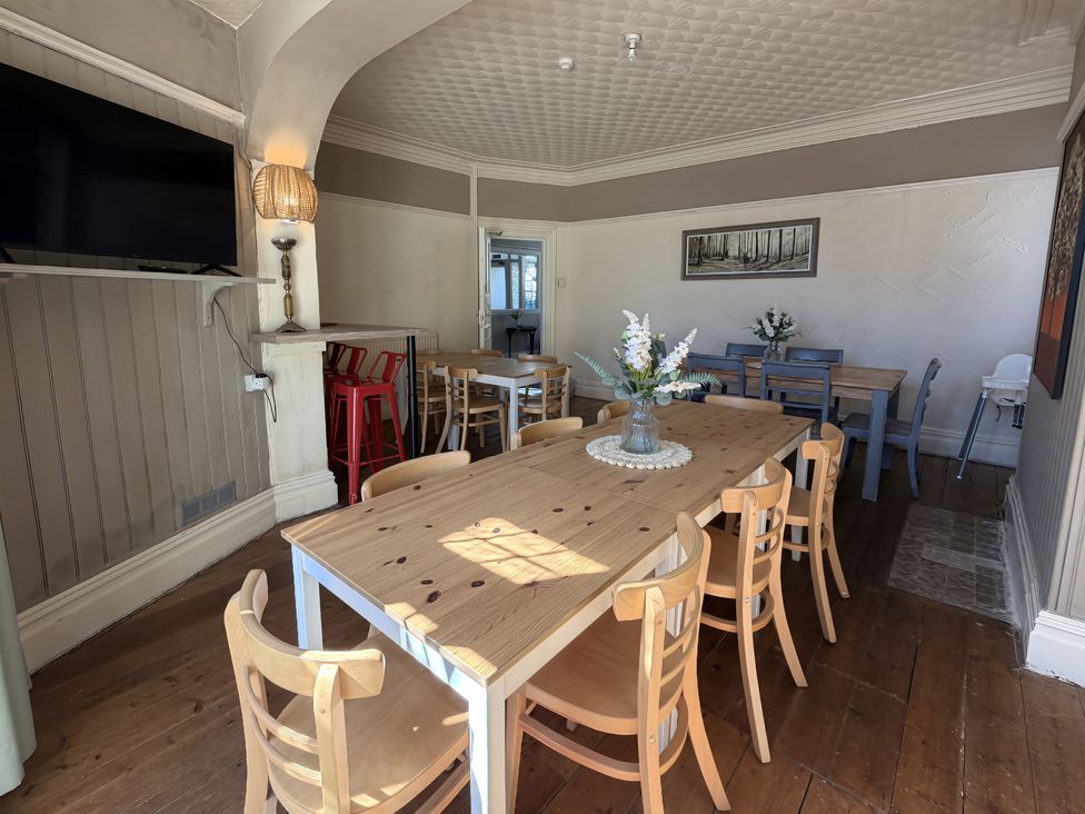 A dining room with a long table and chairs at Avalon Lodge in Bridlington