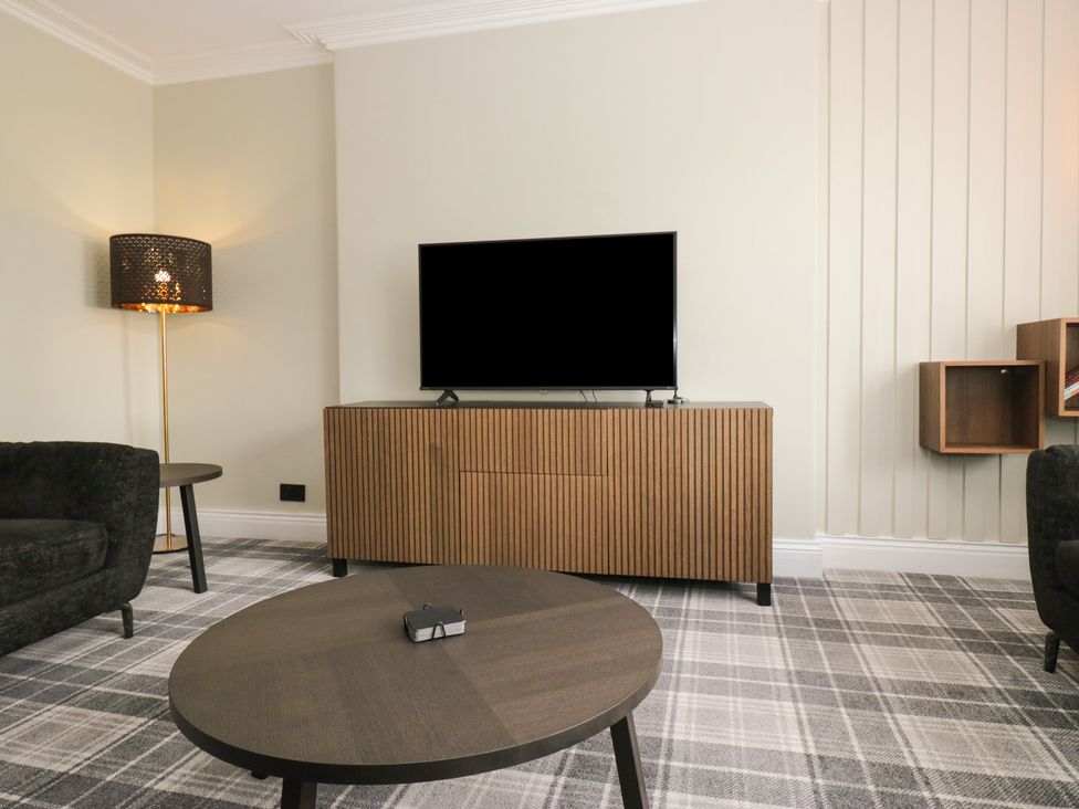 A living room with a television and a lamp at 5 Thornbarrow Road