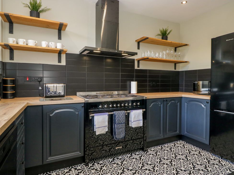 A kitchen with cabinets and black appliances at 5 Thornbarrow Road in 
