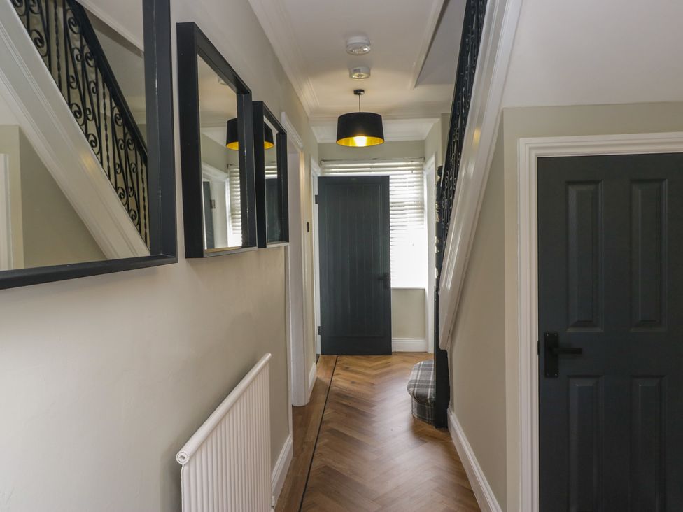 A hallway with stairs and mirrors at 5 Thornbarrow Road