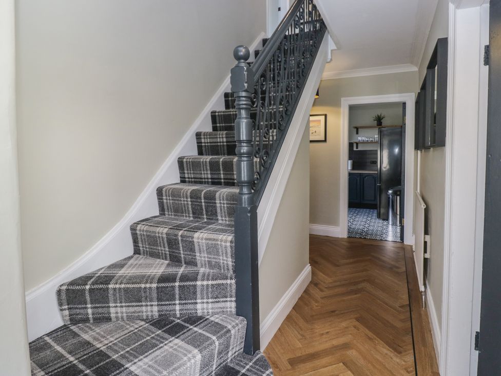 A hallway with a staircase and doorway at 5 Thornbarrow Road