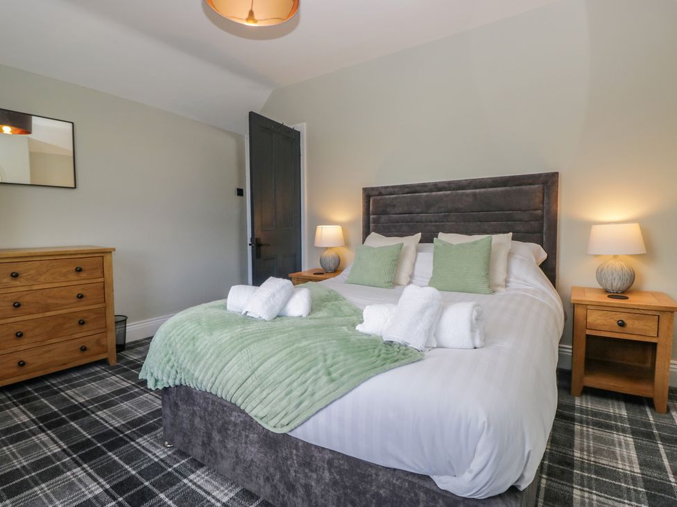 A bedroom with a bed and nightstand at 5 Thornbarrow Road