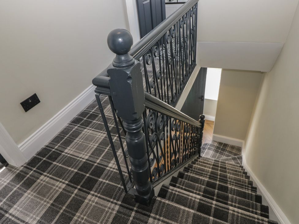 A staircase with a handrail and patterned flooring at 5 Thornbarrow Road 