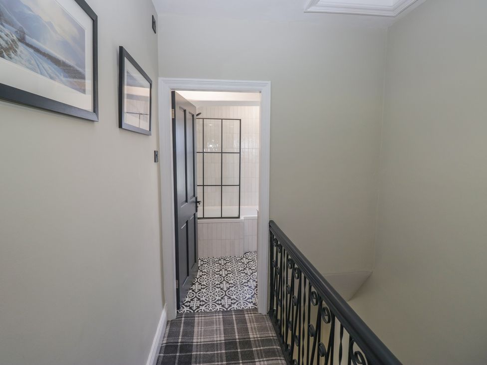 A hallway with a door leading to a bathroom at 5 Thornbarrow Road