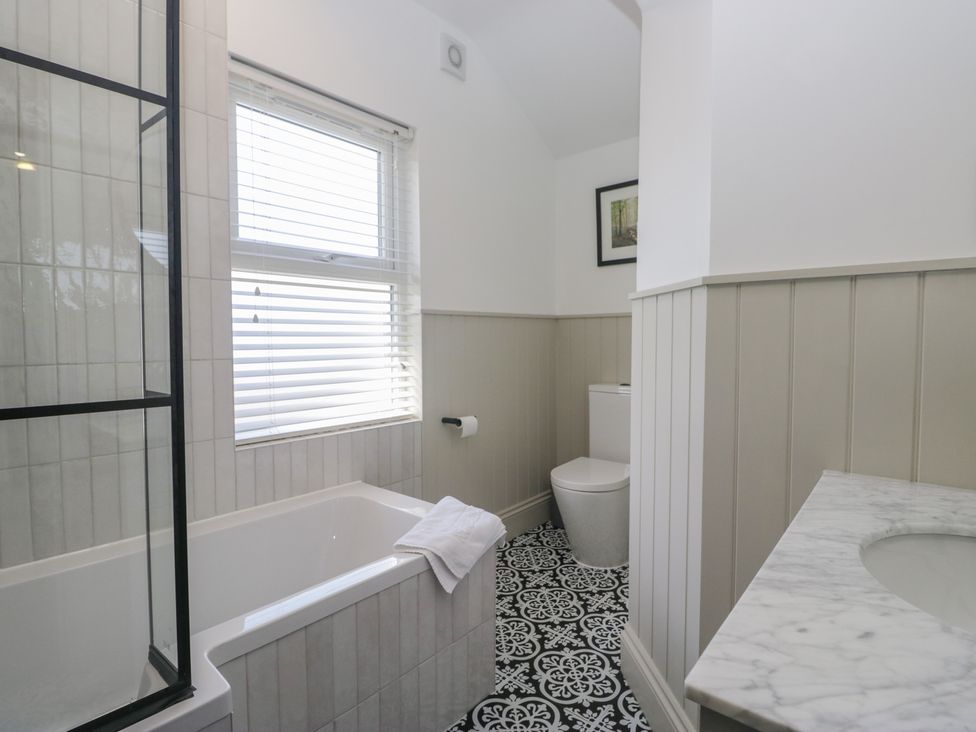 A bathroom with a bathtub and shower at 5 Thornbarrow Road