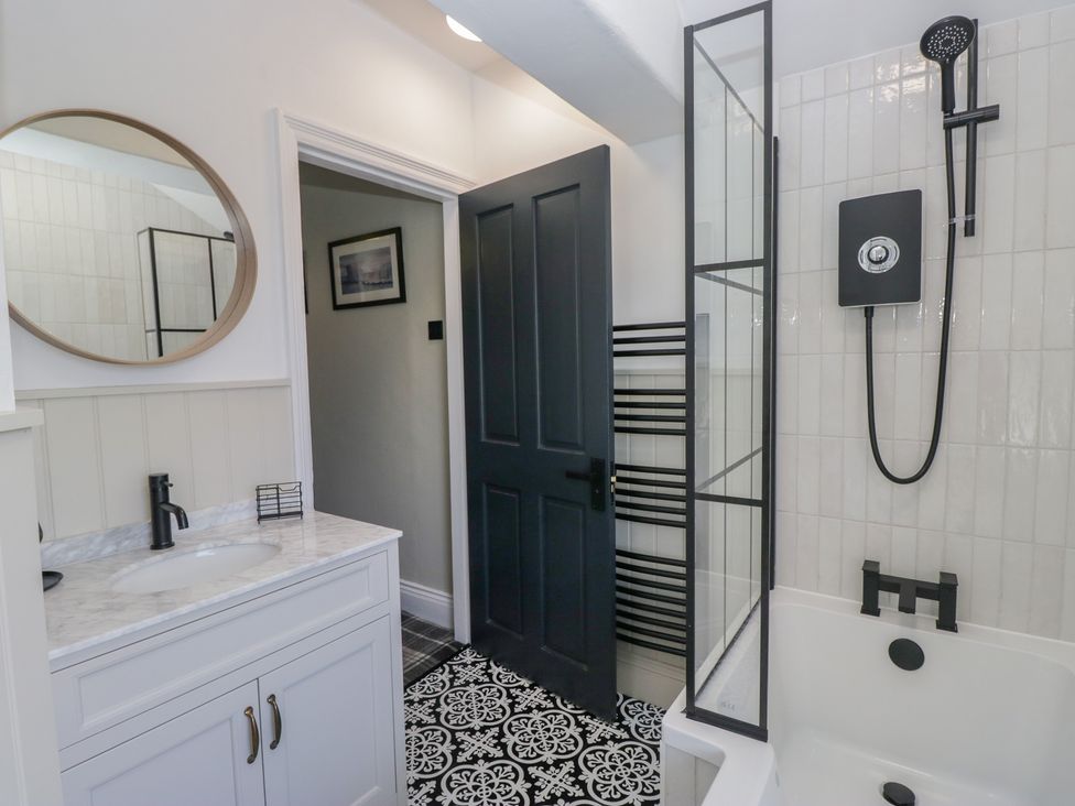 A bathroom with a sink, bath tub, and shower at 5 Thornbarrow Road