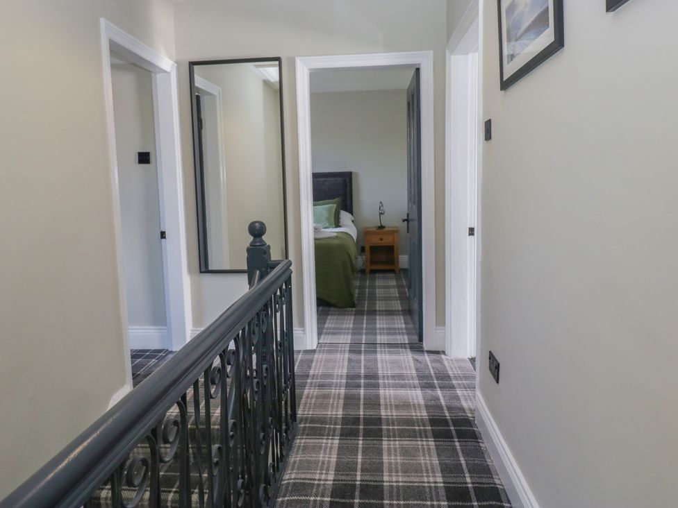 A hallway with doors and a mirror at 5 Thornbarrow Road