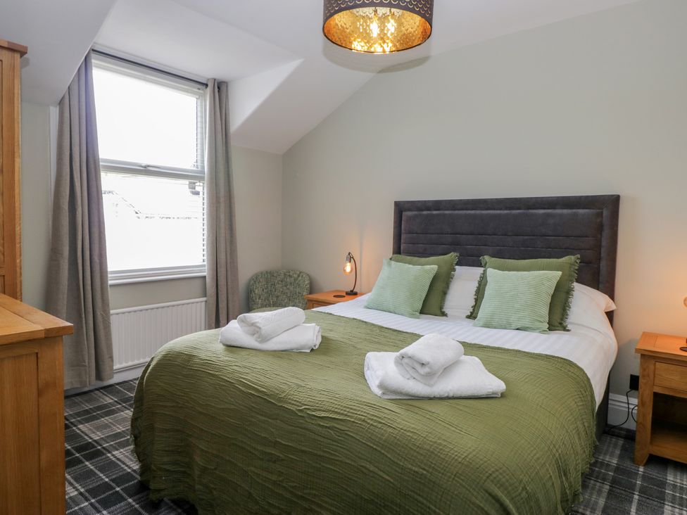 A bedroom with a bed and a chair at 5 Thornbarrow Road