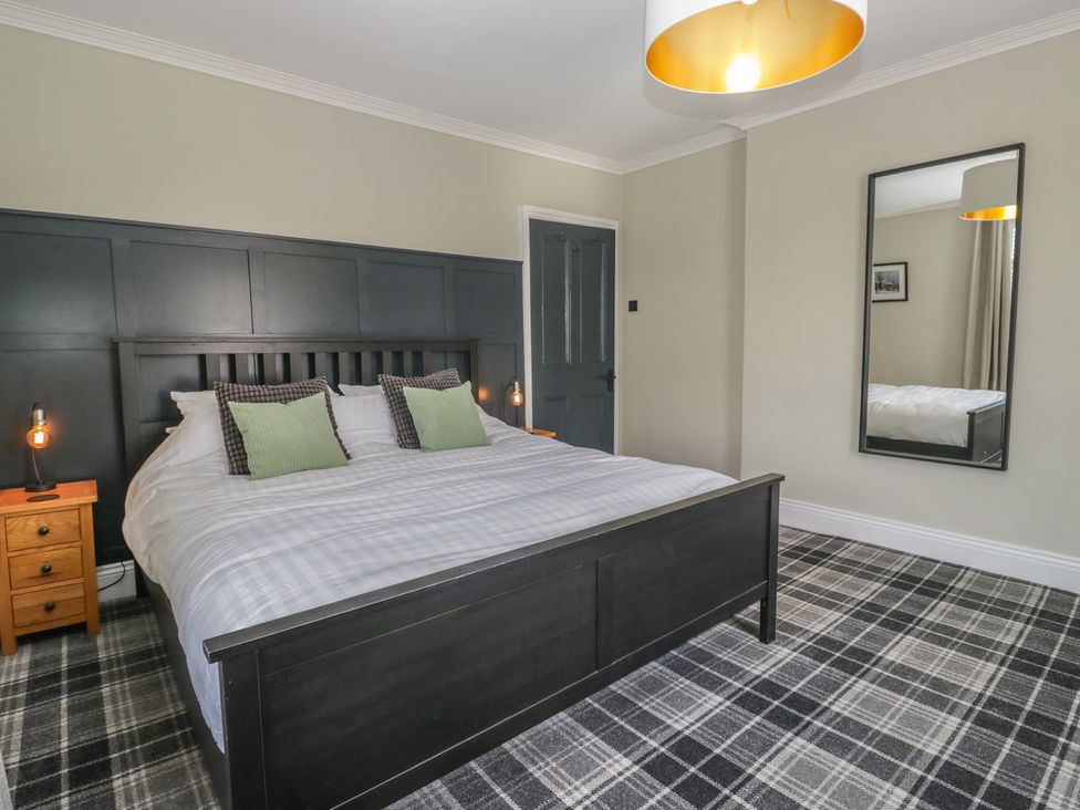 A bedroom with a bed and bedside tables at 5 Thornbarrow Road