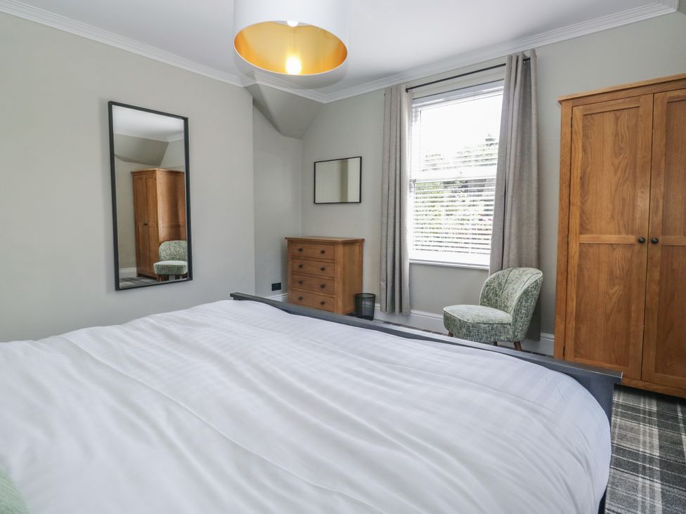 A bedroom with a bed and mirror at 5 Thornbarrow Road